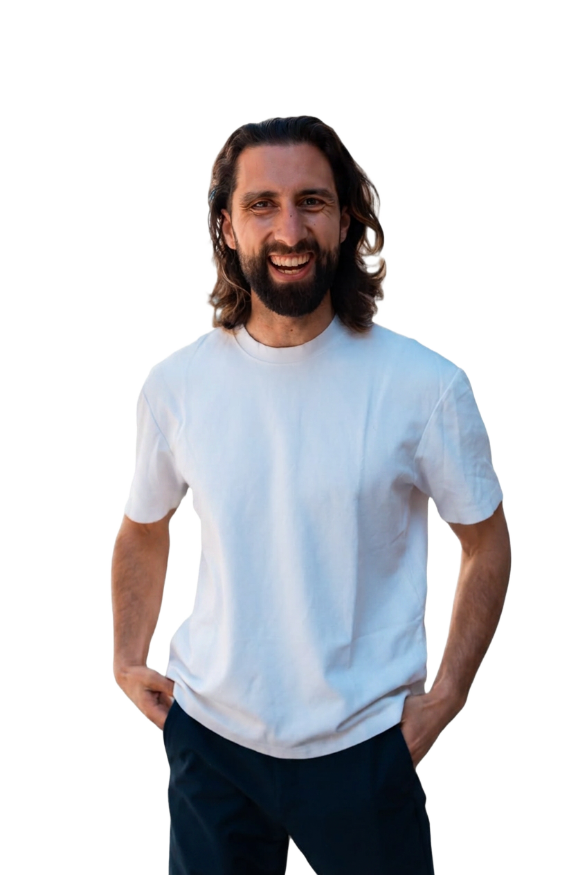 Tarek, charisma coach, smiling in a white t-shirt